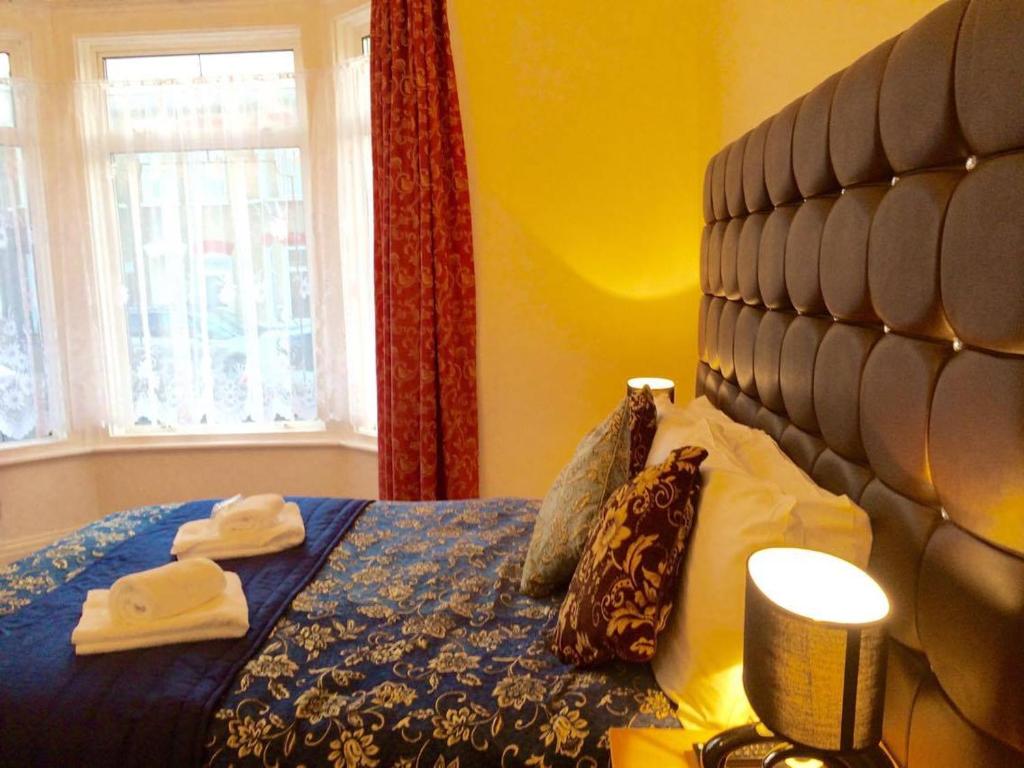 1 dormitorio con 1 cama con edredón azul y ventana en Metro Star, en Londres