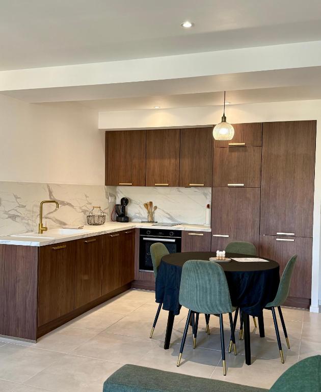une cuisine et une salle à manger avec une table et des chaises dans l'établissement Appartement neuf contemporain, à Lourdes