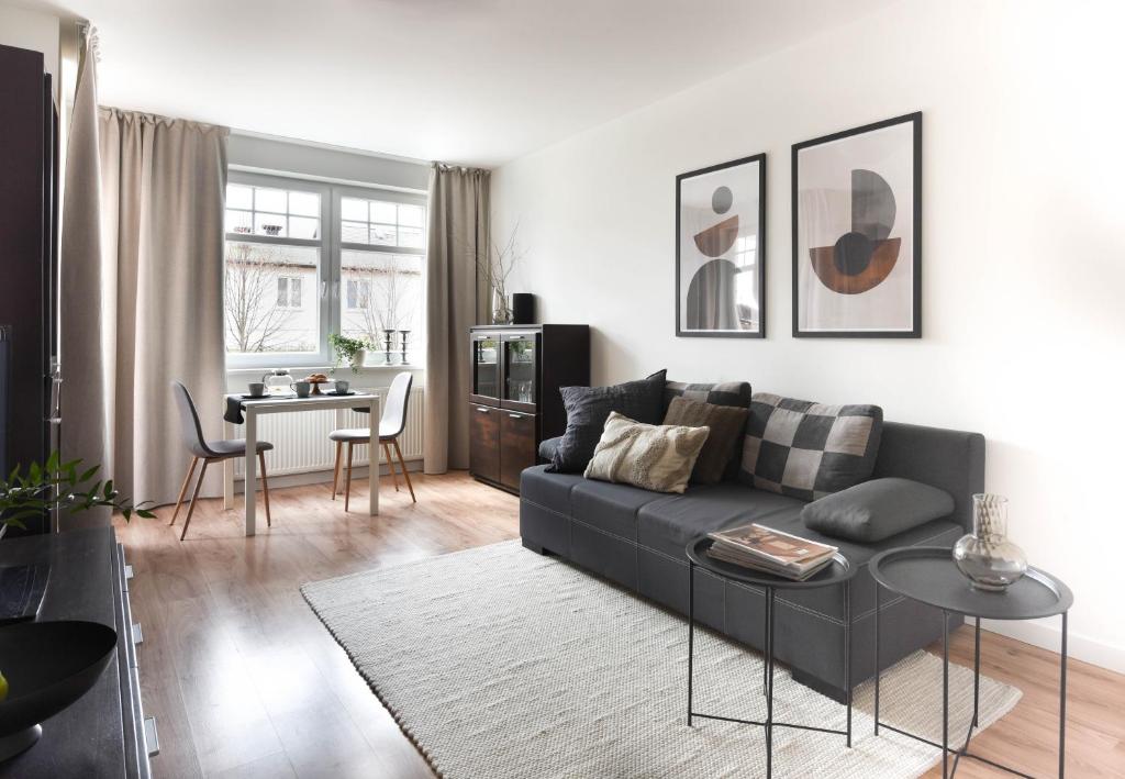 una sala de estar con un sofá y una mesa en Klimatyczny apartament 3-pokojowy, en Olsztyn