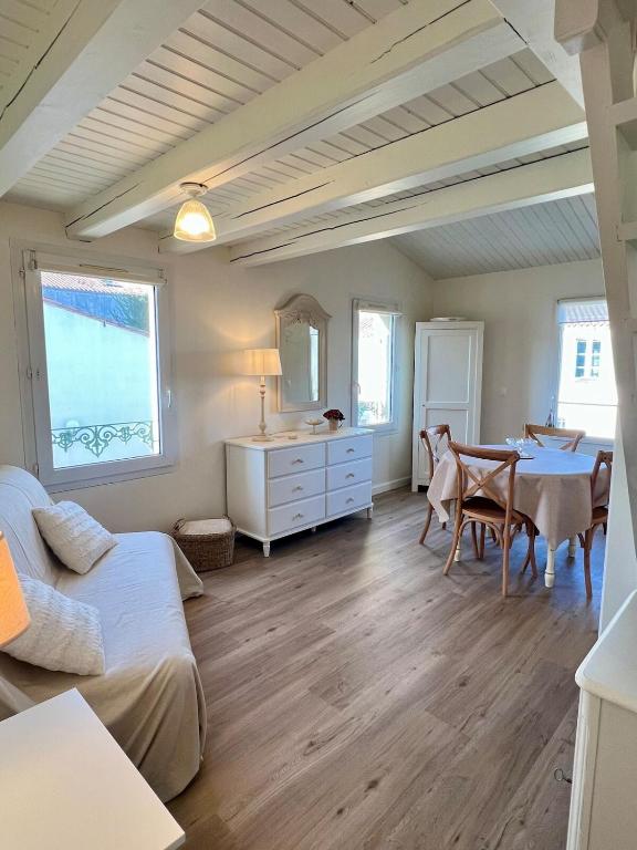 un salon avec une table et une salle à manger dans l'établissement 138 - Roses des Sables Ocean View Full Village Center, à Saint-Martin-de-Ré