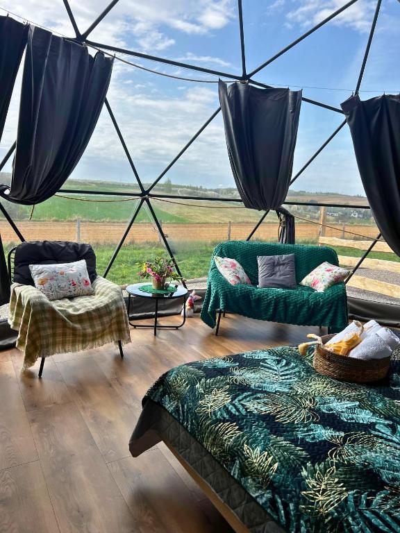 a room with two beds and a view of a field at Glamping Sfera Marzeń in Szewna