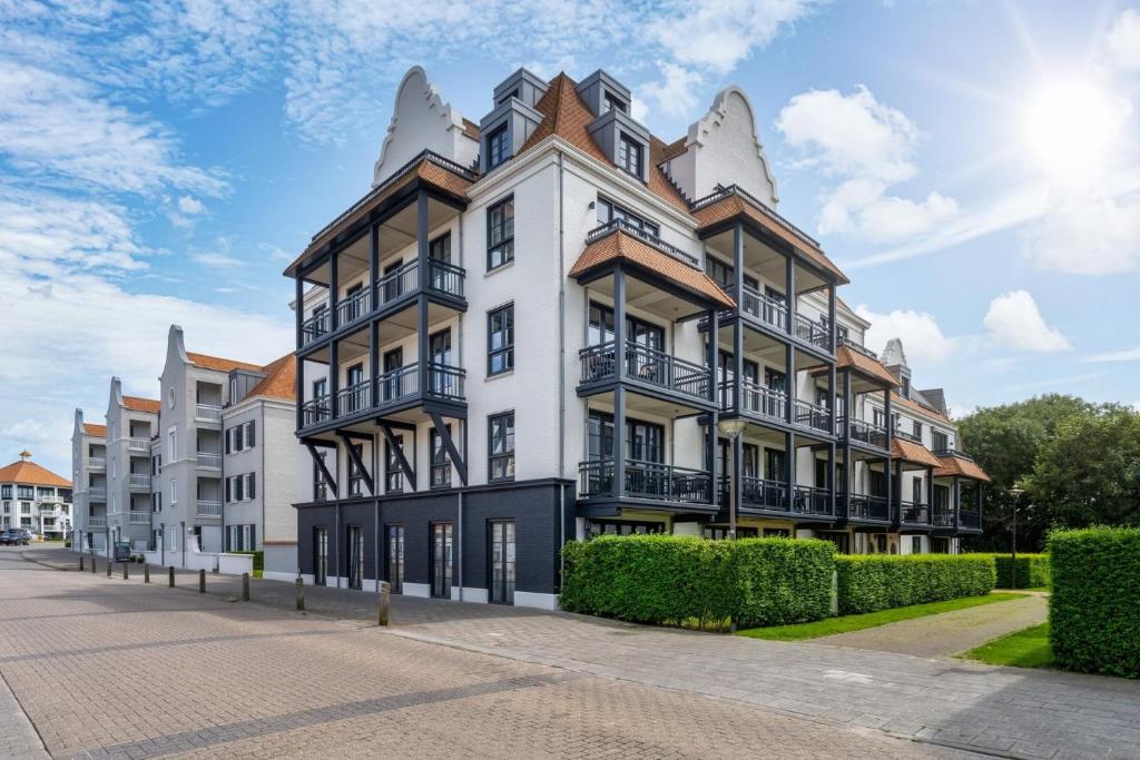 an apartment building with balconies on a street at Appartement Duinhof, Cadzand-Bad in Cadzand-Bad