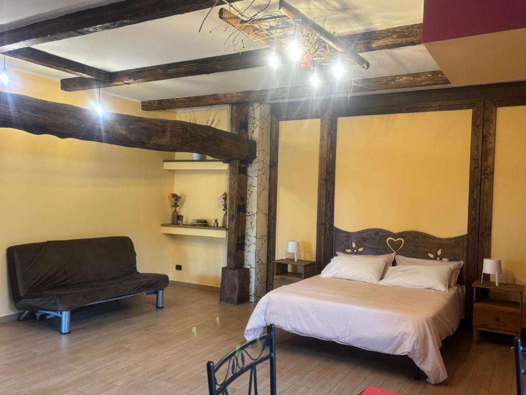 a bedroom with a large bed and a chair at Etna Winery in Zafferana Etnea