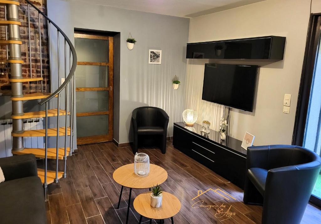 a living room with two tables and a flat screen tv at Maison cosy avec jardin privé proche gare in Le Mans