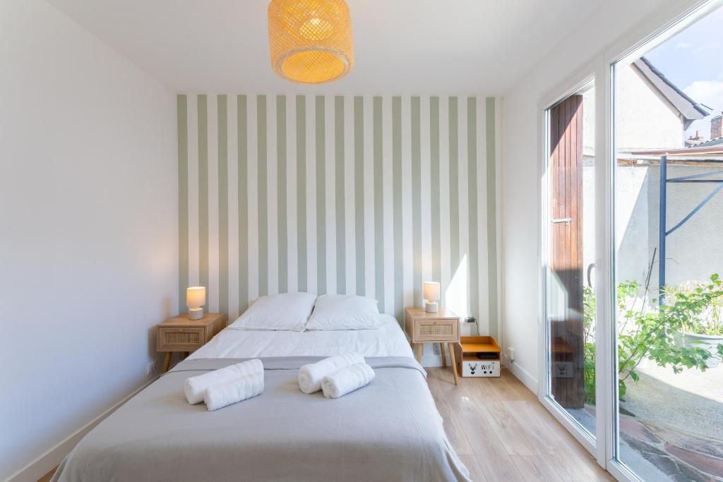 une chambre avec deux lits et une grande fenêtre dans l'établissement Le Pré Vert - Terrasse - Calme - Netflix, au Mans