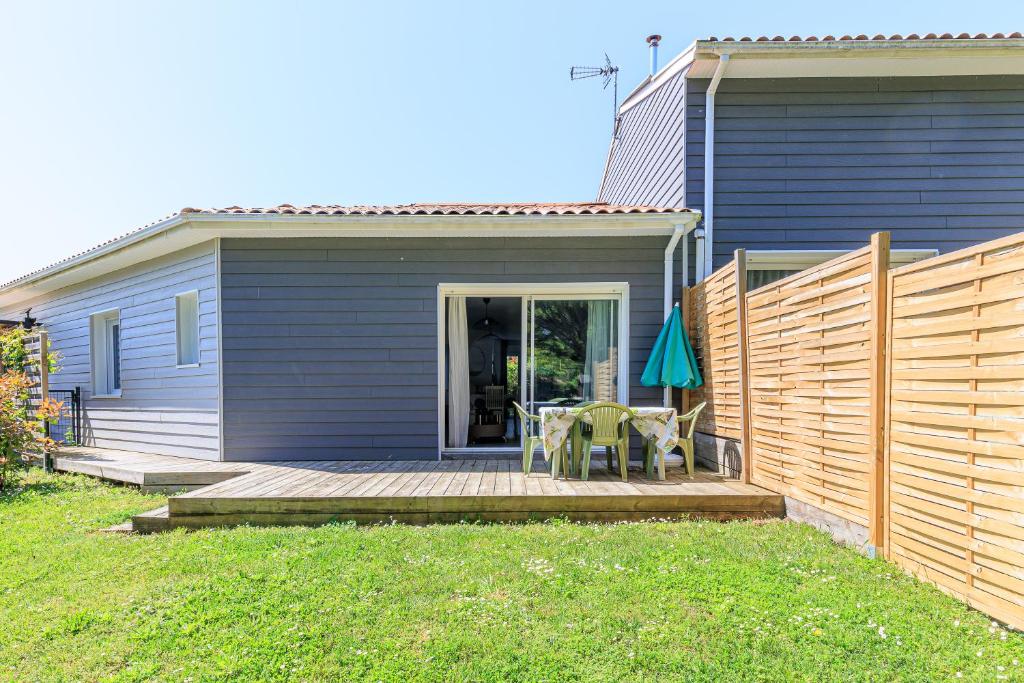 a house with a deck with a table and chairs on it at Appartement 6 Personnes Soustons in Soustons
