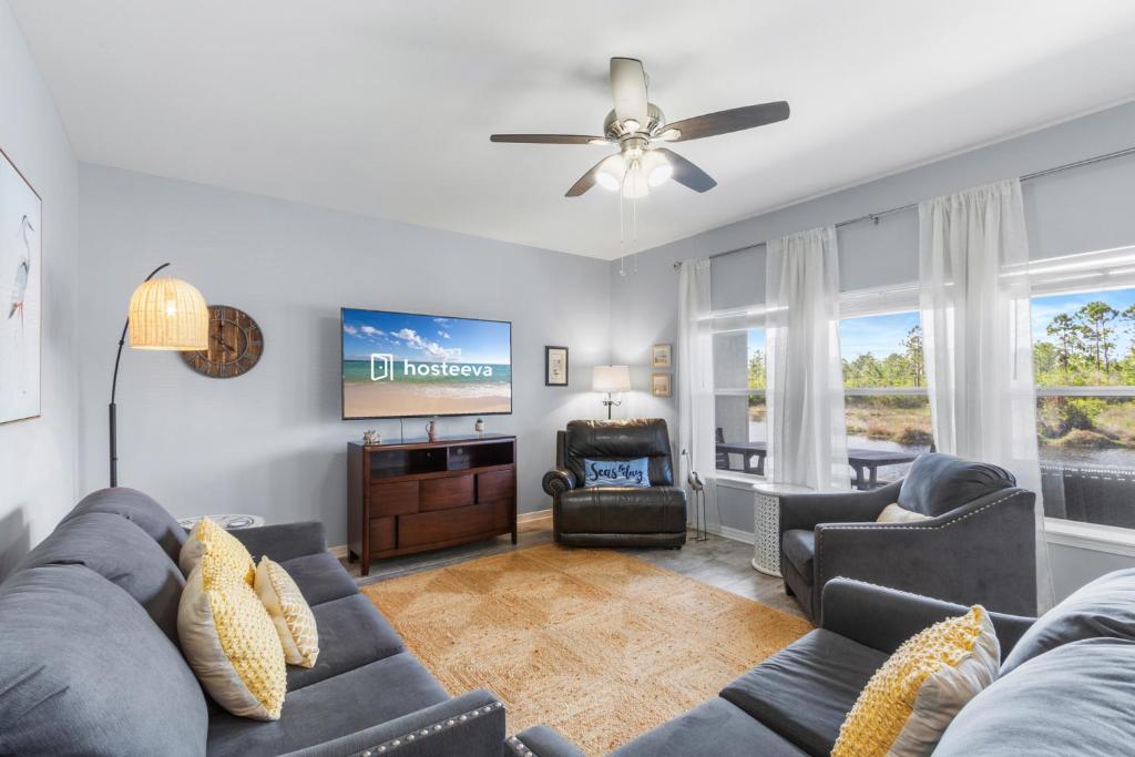 a living room with a couch and a tv at Romar Lakes 103B in Orange Beach