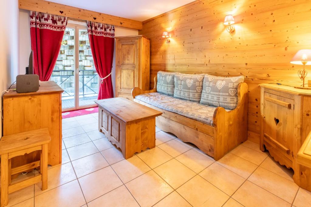 - un salon en rondins avec un canapé et une table dans l'établissement Alba, les cures thermales de Brides-les-Bains, à Brides-les-Bains