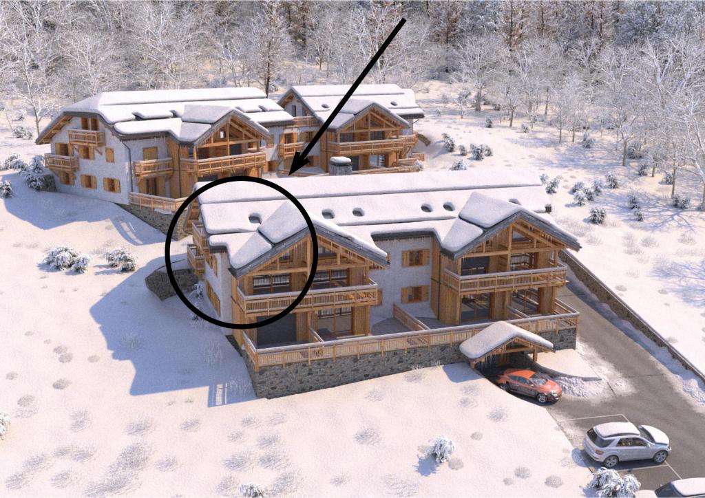 - une vue aérienne sur une maison recouverte de neige dans l'établissement LA TANIÈRE DES OURSONS - Appartement duplex NEUF 9-10 pers vue pistes avec garages, à Montgenèvre
