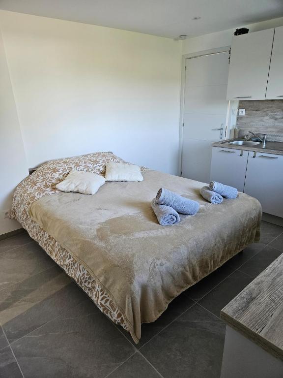 une chambre avec un grand lit avec des serviettes dessus dans l'établissement La petite bulle d'Aurel, à Quesques