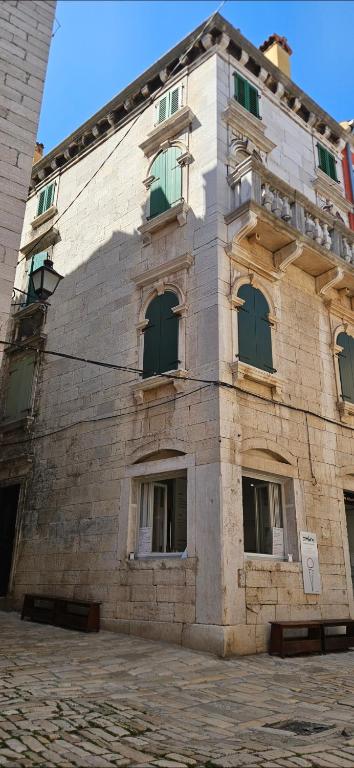 a large stone building with green windows on it at B&B Palace Basilico 1580. in Rovinj