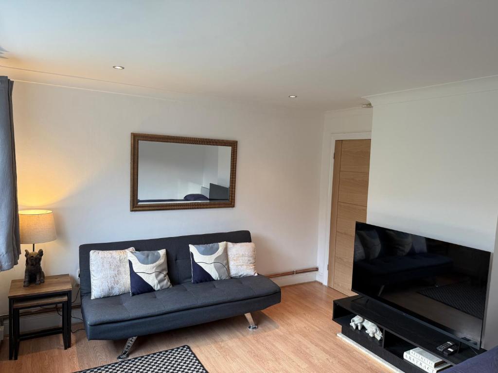 a living room with a couch and a mirror at Apartment close to London Stansted airport in Great Parndon