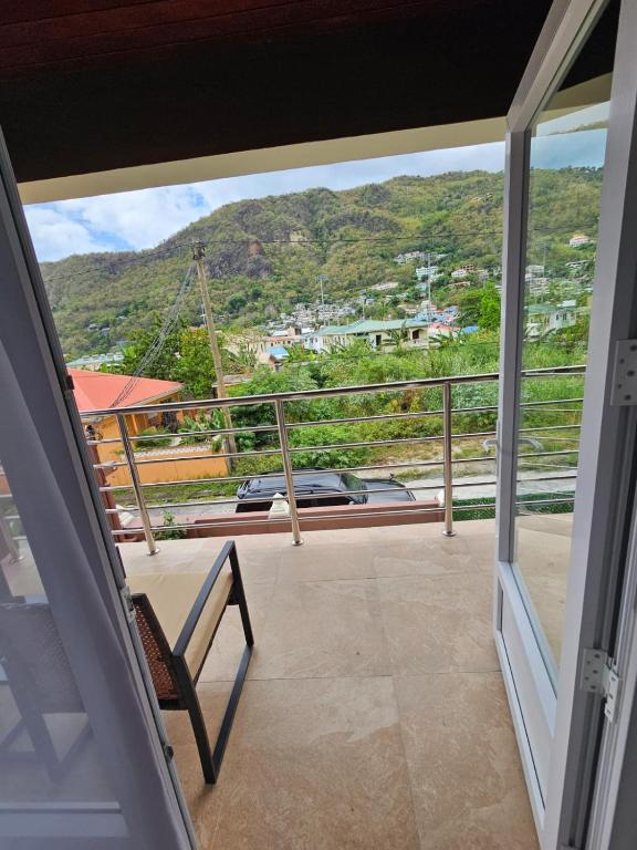 a balcony with a chair and a view of a mountain at Agape Suites-Room 3- 1st Floor in Soufrière