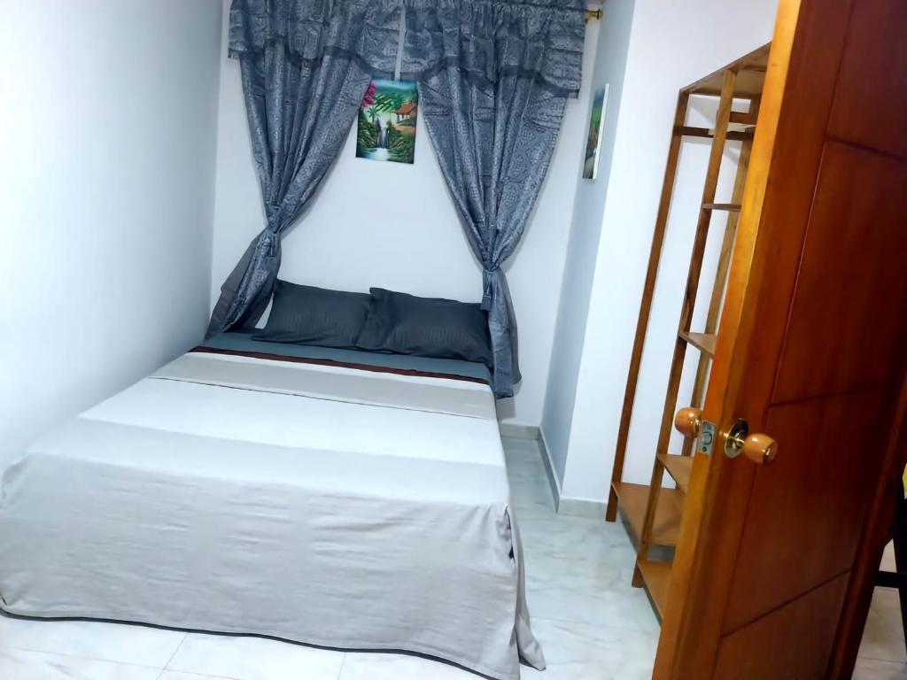 Una cama pequeña en una habitación con ventana. en El Apartastudio de Dña Gilma en Pijao, en Pijao