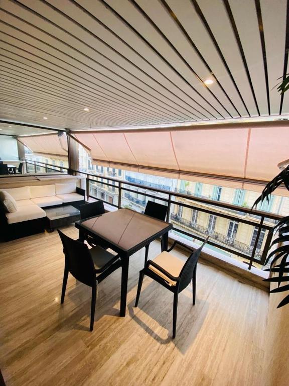 a room with a table and chairs and a balcony at GRAY D ALBION Residence in Cannes