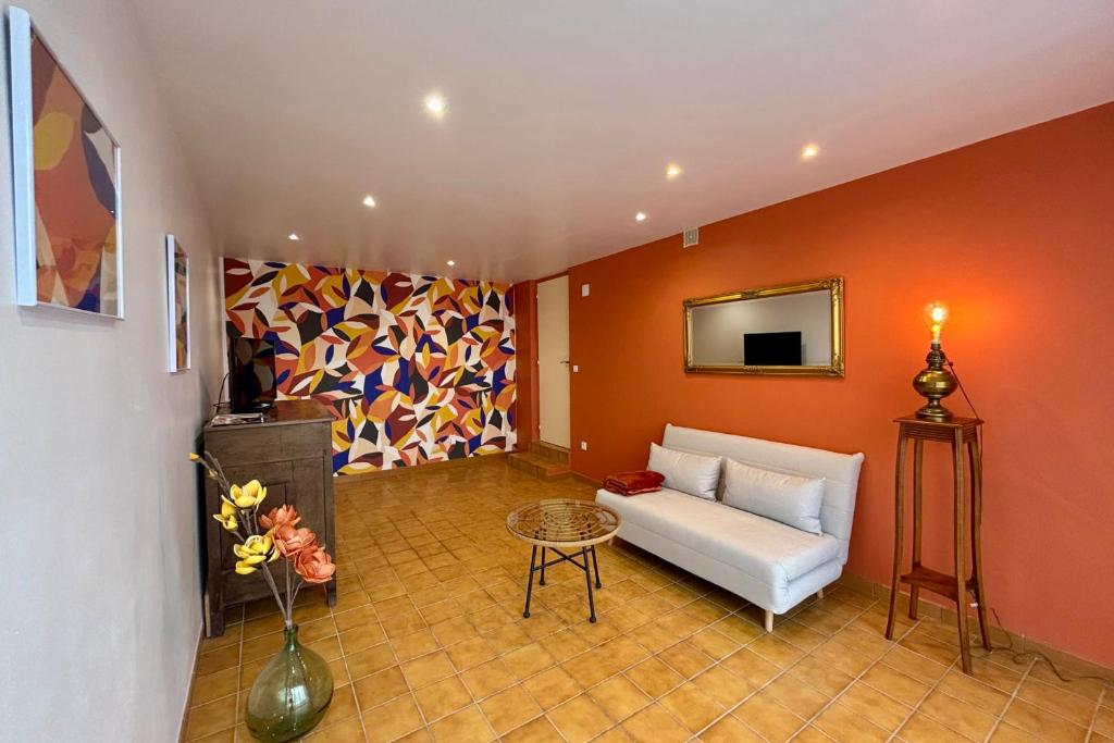 un salon avec un canapé blanc et un tableau dans l'établissement Casa Duhamel - T2 Paisible avec Stationnement - Proche Centre-ville Brive, à Brive-la-Gaillarde