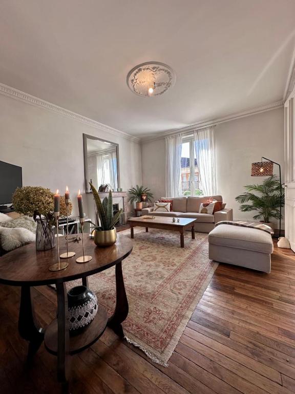 un salon avec un canapé et une table dans l'établissement Casa Jaurès - T4 style haussmannien - Proche gare - Place de parking, à Brive-la-Gaillarde