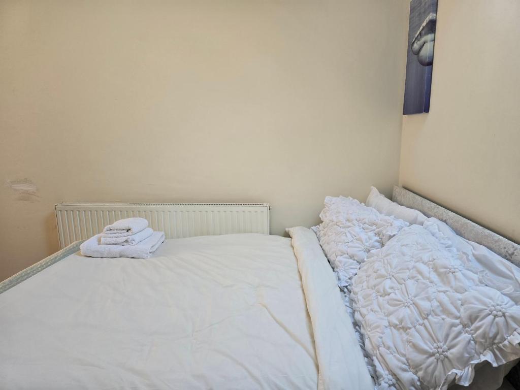 a white bed with two towels on top of it at Realwood Homes- Birrell Road in Nottingham