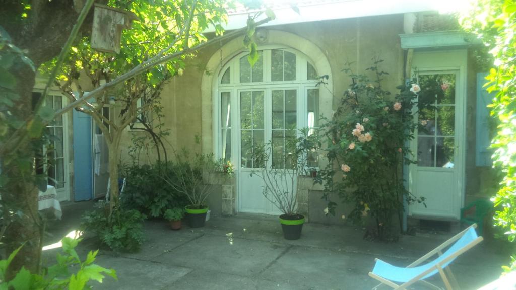 una casa con una porta bianca e alcune piante di Arcachonaise à 50 m de la plage, Arcachon Centre ad Arcachon