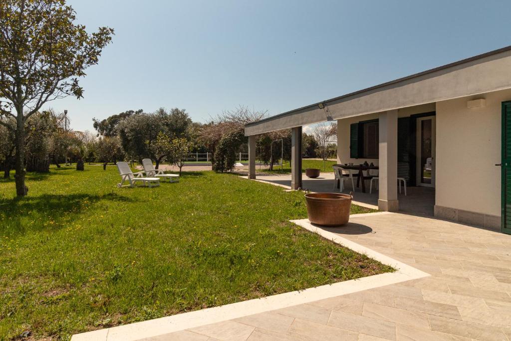 a building with a yard with chairs and a patio at Cicale relaxing home - aria condizionata, parcheggio, giardino in Termoli