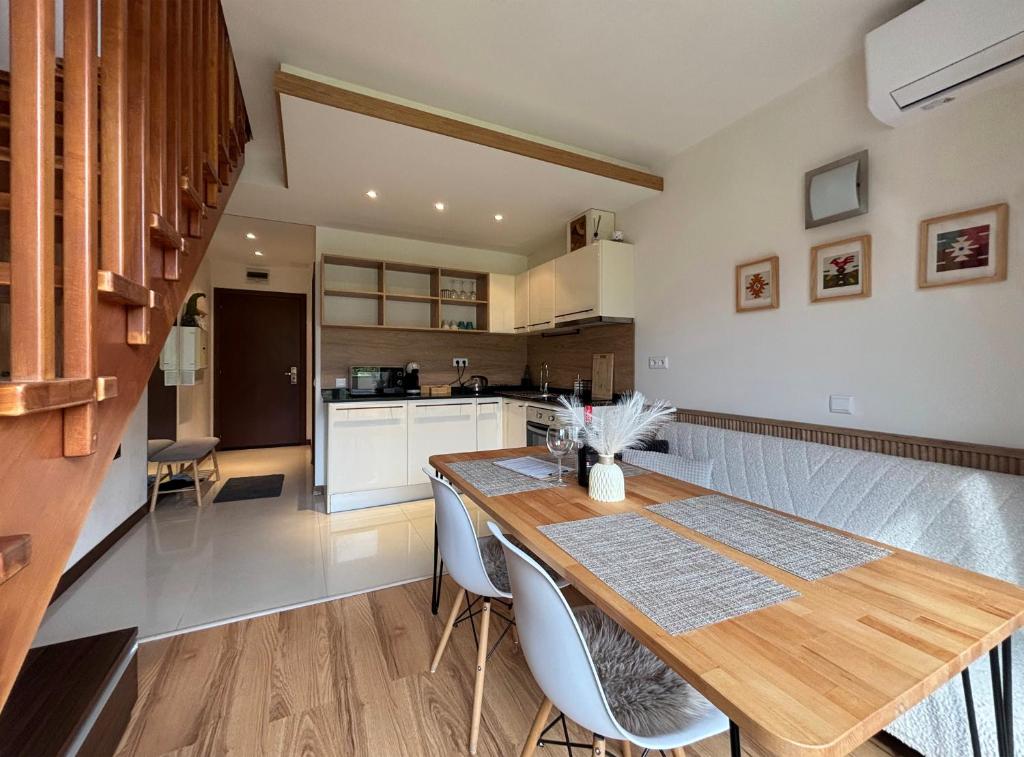 a kitchen and dining room with a wooden table and chairs at TERRA Vista Penthouse near Pirin Golf and Bansko in Razlog