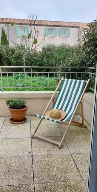 une chaise bleue et blanche assise sur un balcon dans l'établissement 170 - Le Clémenceau, à Saint-Martin-de-Ré