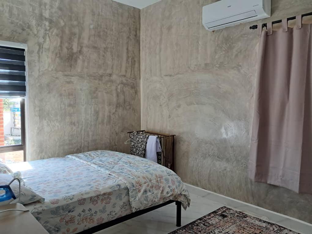 En eller flere senge i et værelse på Anggun Homestay