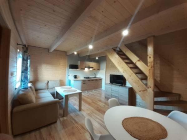 a living room with a couch and a table and a kitchen at Domki na kamieńcu 47c in Ustrzyki Dolne