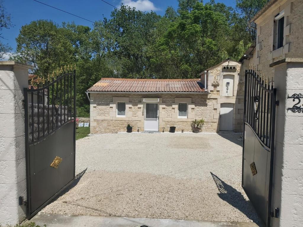 une porte vers une maison en pierre avec un garage dans l'établissement Maison de charme bord de rivière, à Le Chay