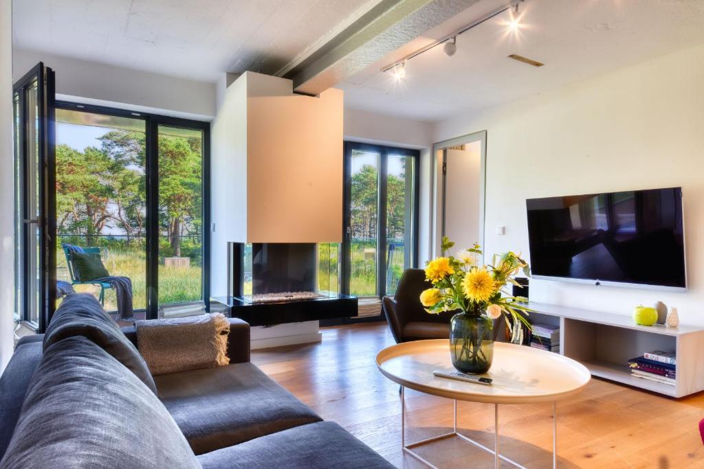 een woonkamer met een bank en een tv bij Ferienwohnung Ostseeloft 5 im Haus Prora Düne 7 in Binz