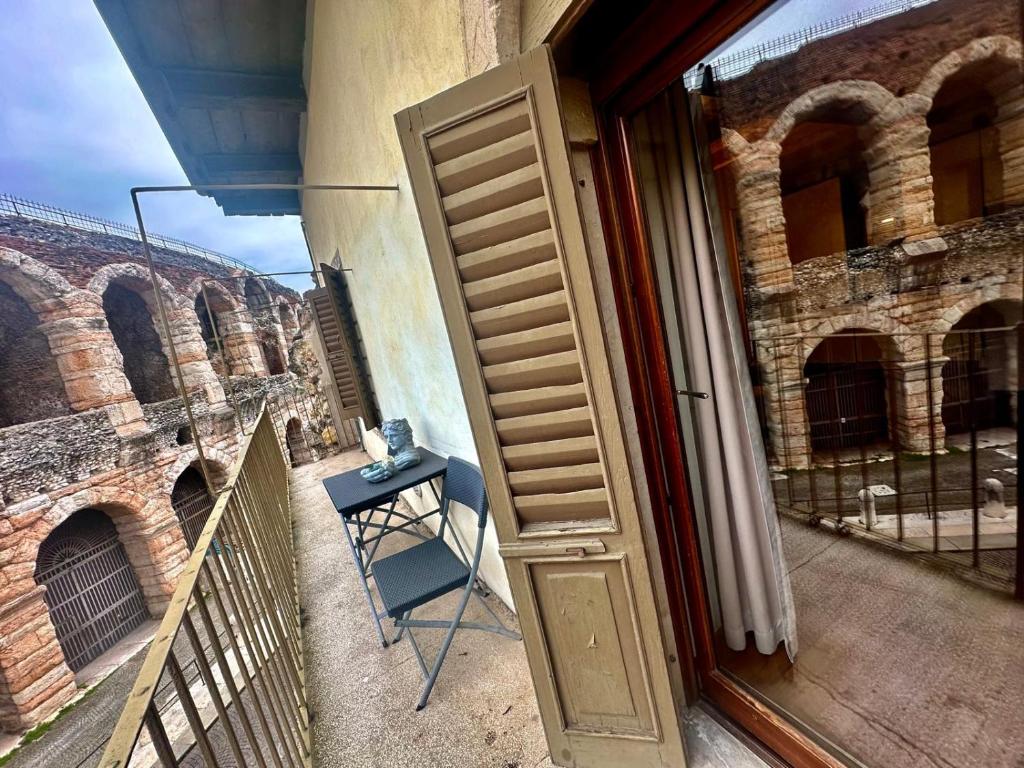 eine offene Tür zu einem Balkon mit einem Tisch neben einem Gebäude in der Unterkunft Le STELLE SULL'ARENA in Verona
