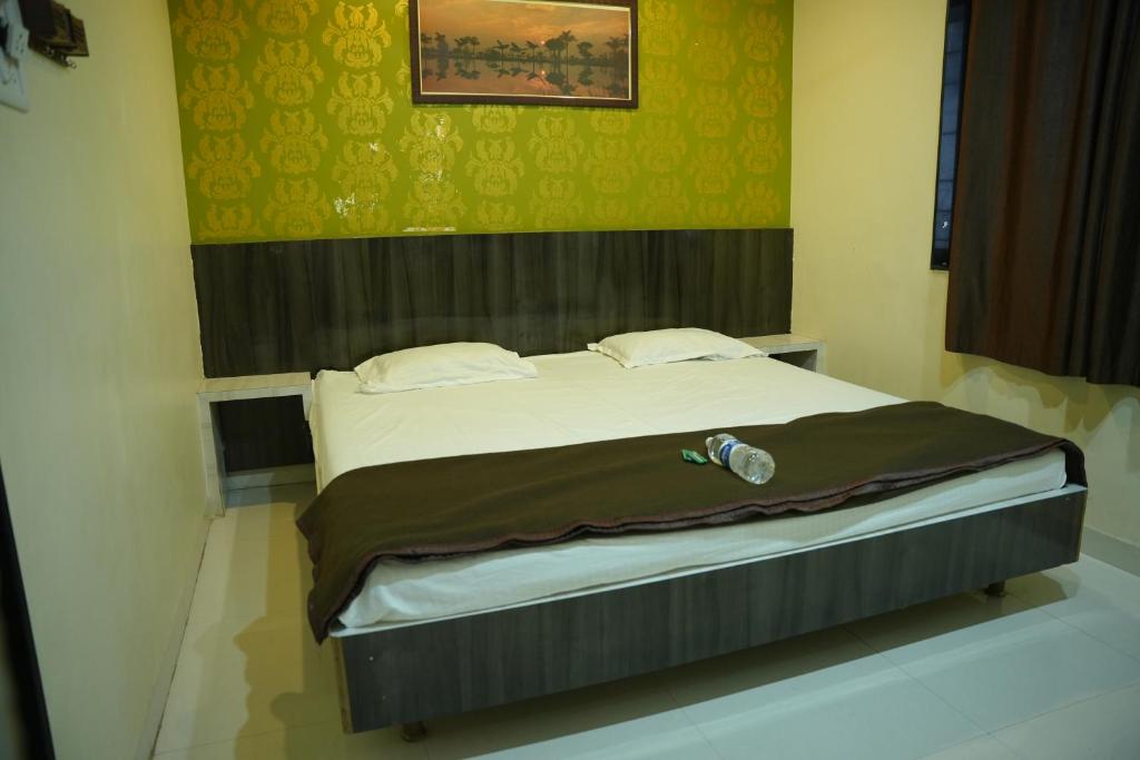 Una cama grande en una habitación con aversión en New Palange Bhakt Niwas, en Tuljapur