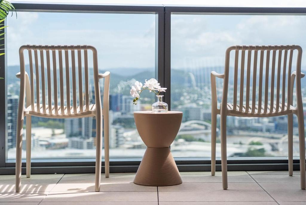 dos sillas y un jarrón delante de una ventana en The Oracles Tower - Lv 31 Dreamy Stay Above The Star Casino, en Brisbane