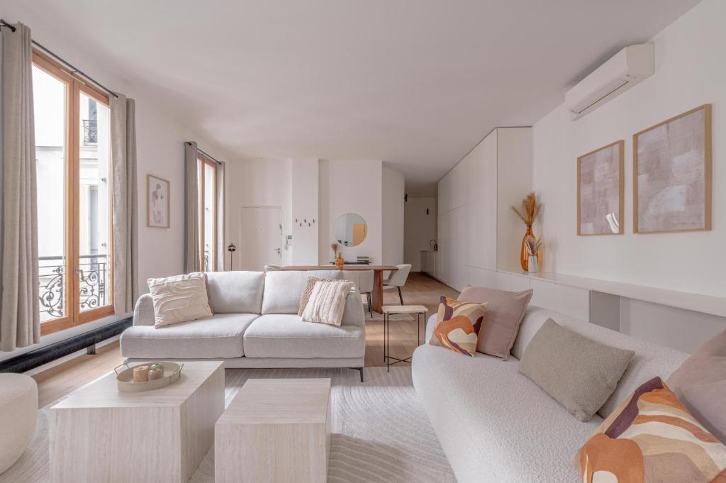 - un salon avec deux canapés blancs et une table dans l'établissement Beautiful Duplex Heart of Paris, à Paris