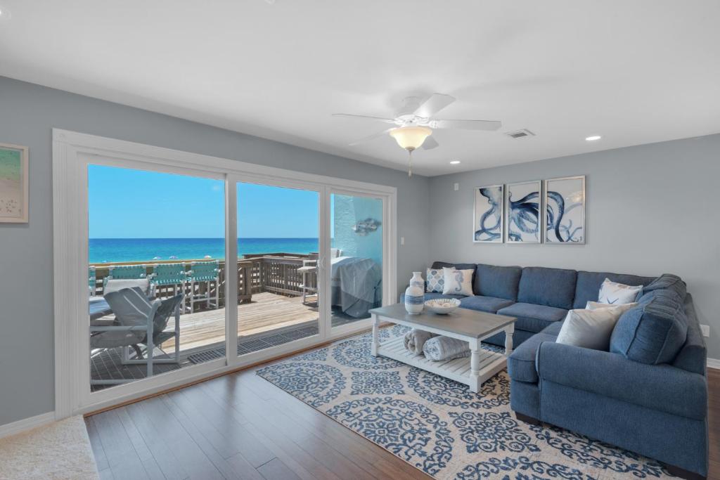 ein Wohnzimmer mit einem blauen Sofa und Meerblick in der Unterkunft Once Upon A Tide by Gulf Coast Getaways in Navarre