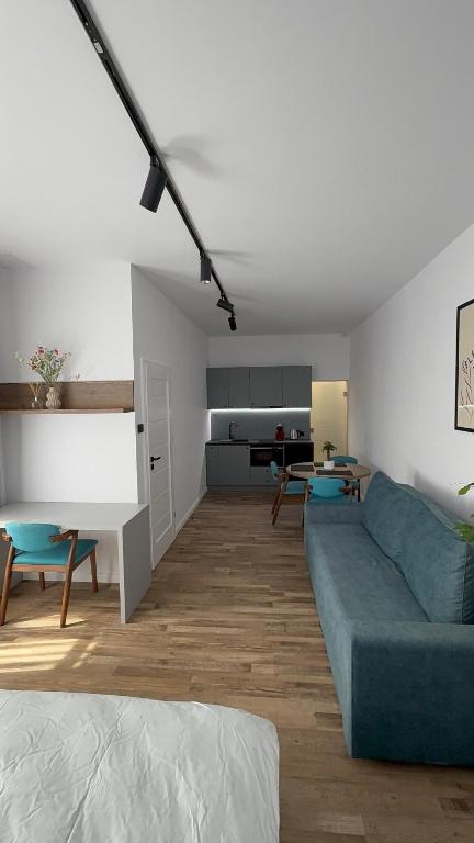 a living room with a blue couch and a kitchen at Nova Central in Cluj-Napoca