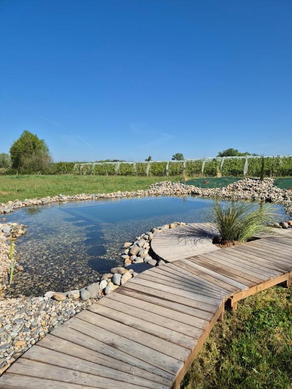 une passerelle en bois au-dessus d'un étang avec des rochers dans l'établissement L'orée du bois aux portes de Montauban, à Albias