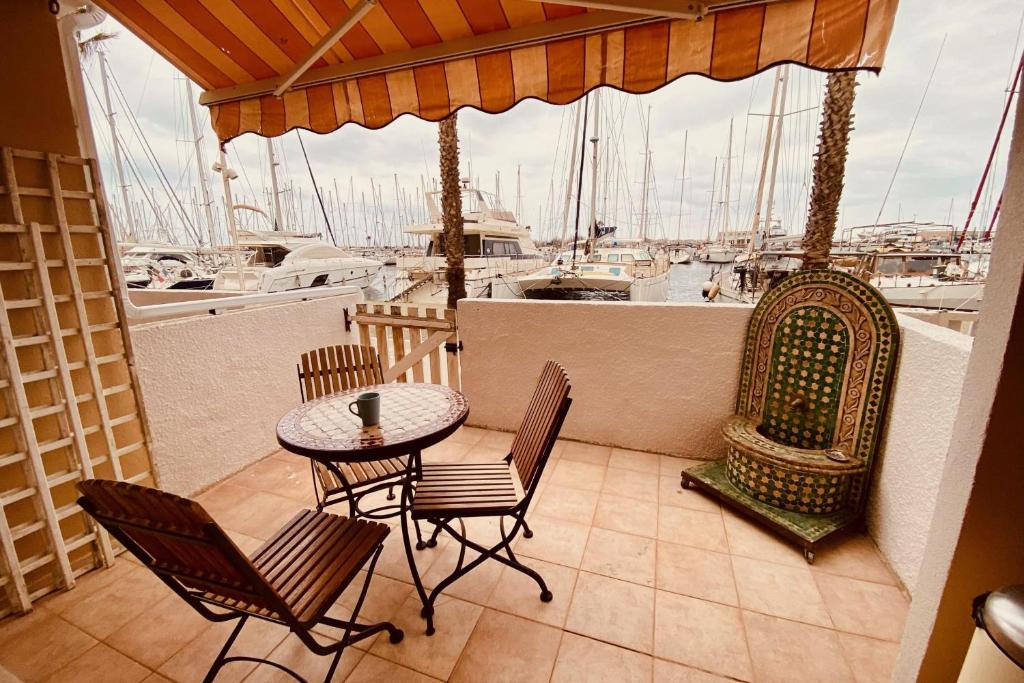 d'un balcon avec une table et des chaises ainsi qu'un port de plaisance. dans l'établissement Apartment of 26 m2 with view on the boats, à Gruissan