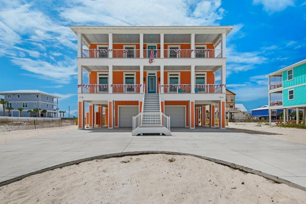 a large house on the beach with a building at Peachy Queen by Gulf Coast Getaways in Navarre