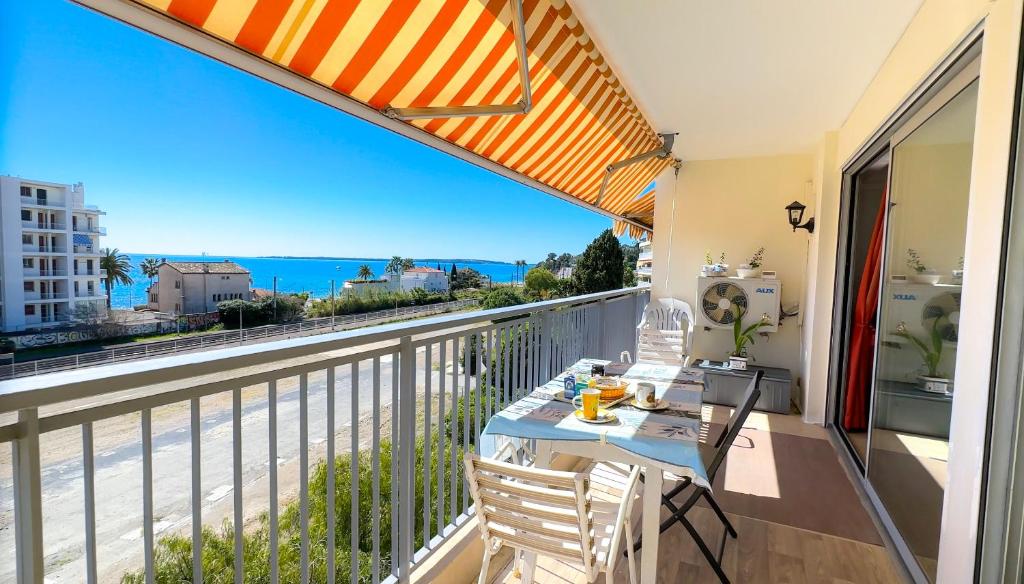 un balcon avec une table et une vue sur l'océan dans l'établissement Apt Golfe-Juan à 300 m de la plage et près de Cannes 2, Centre et Gare, à Vallauris