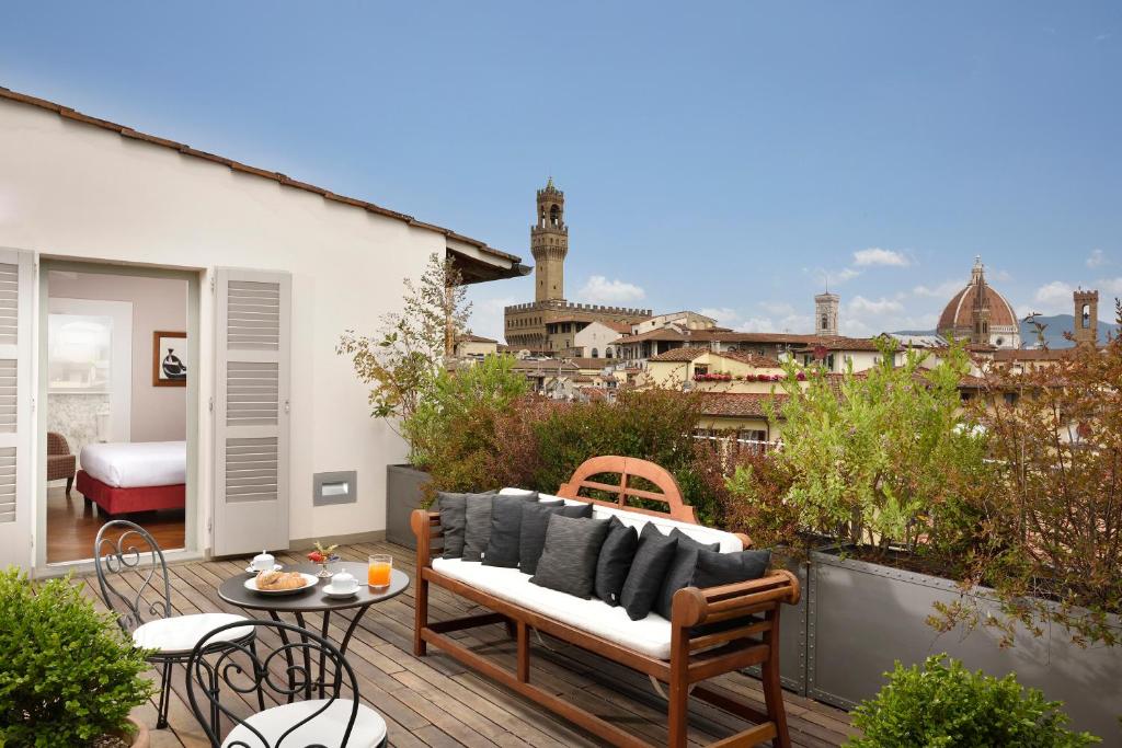 a patio with a couch and a table on a balcony at Hotel Balestri - WTB Hotels in Florence
