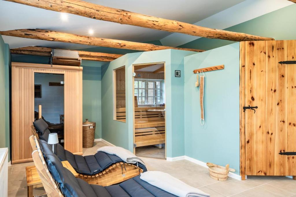 a master bathroom with blue walls and wooden beams at Ostseeurlaub mit Parkblick und Sauna in Rabenholz
