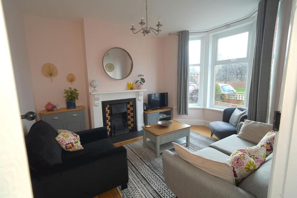 a living room with a couch and a fireplace at Parkside View, Exeter in Alphington