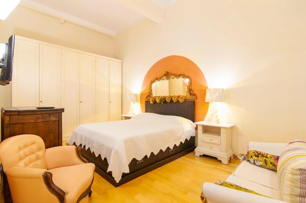 una camera da letto con un letto, una sedia e uno specchio di Casa Matilde a Verona