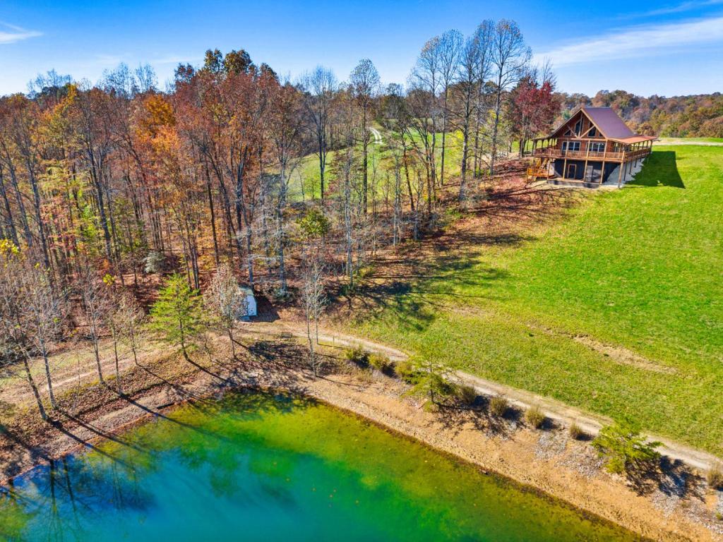 una vista aerea di una casa su una collina vicino a un lago di Private Lake Hot Tub Fire Pit 5 Min to Hollerwood a Campton
