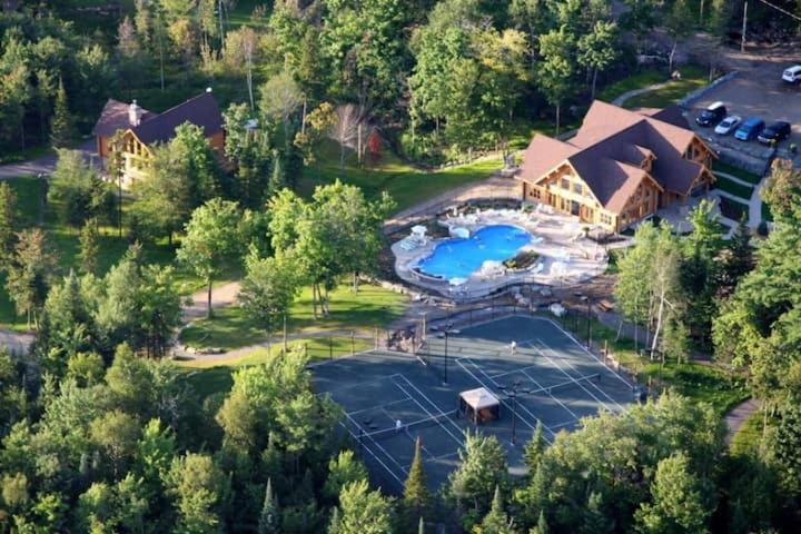 an aerial view of a large house with a lake at Chalet 20 Ours, Lac Fiddler in Mille-Isles