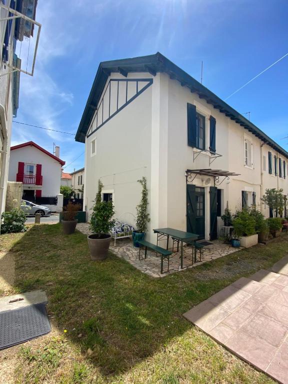 une maison blanche avec une table de pique-nique dans la cour dans l'établissement Biarritz, Côte des Basques House, à Biarritz