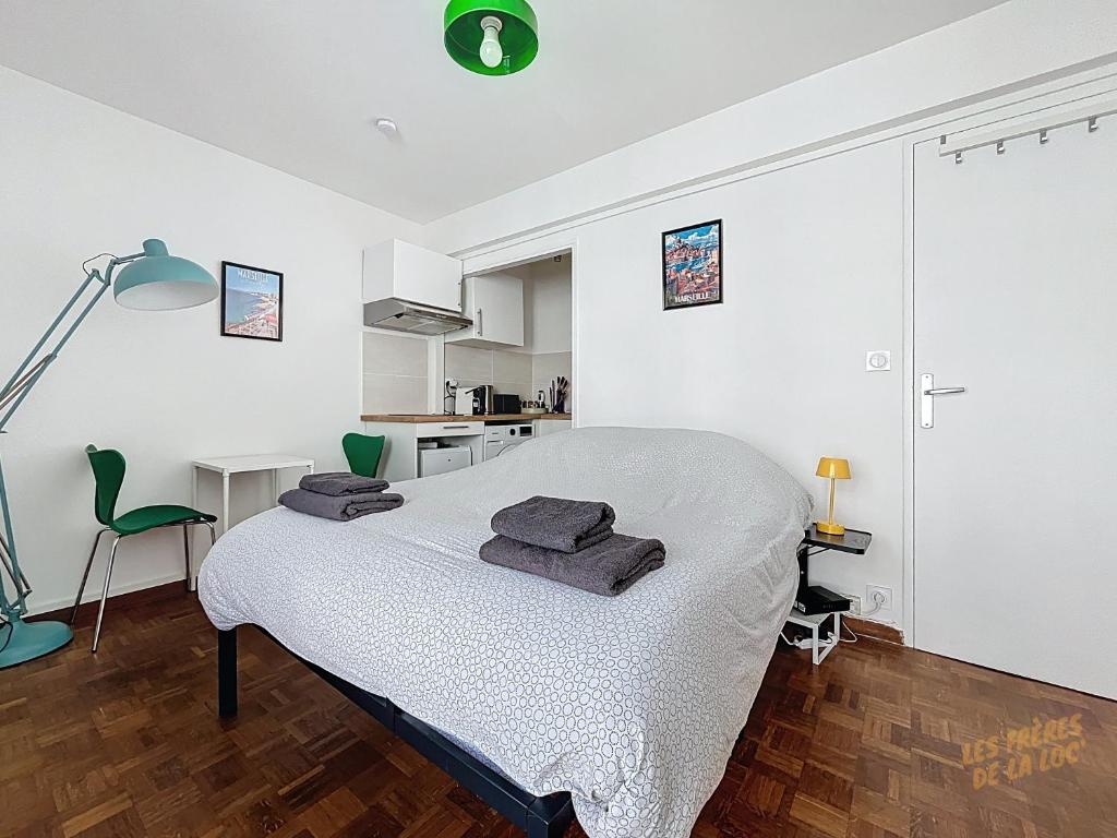 une chambre avec un lit avec des serviettes dessus dans l'établissement Studio Cozy - Gare Saint Charles - Les Frères de la Loc', à Marseille