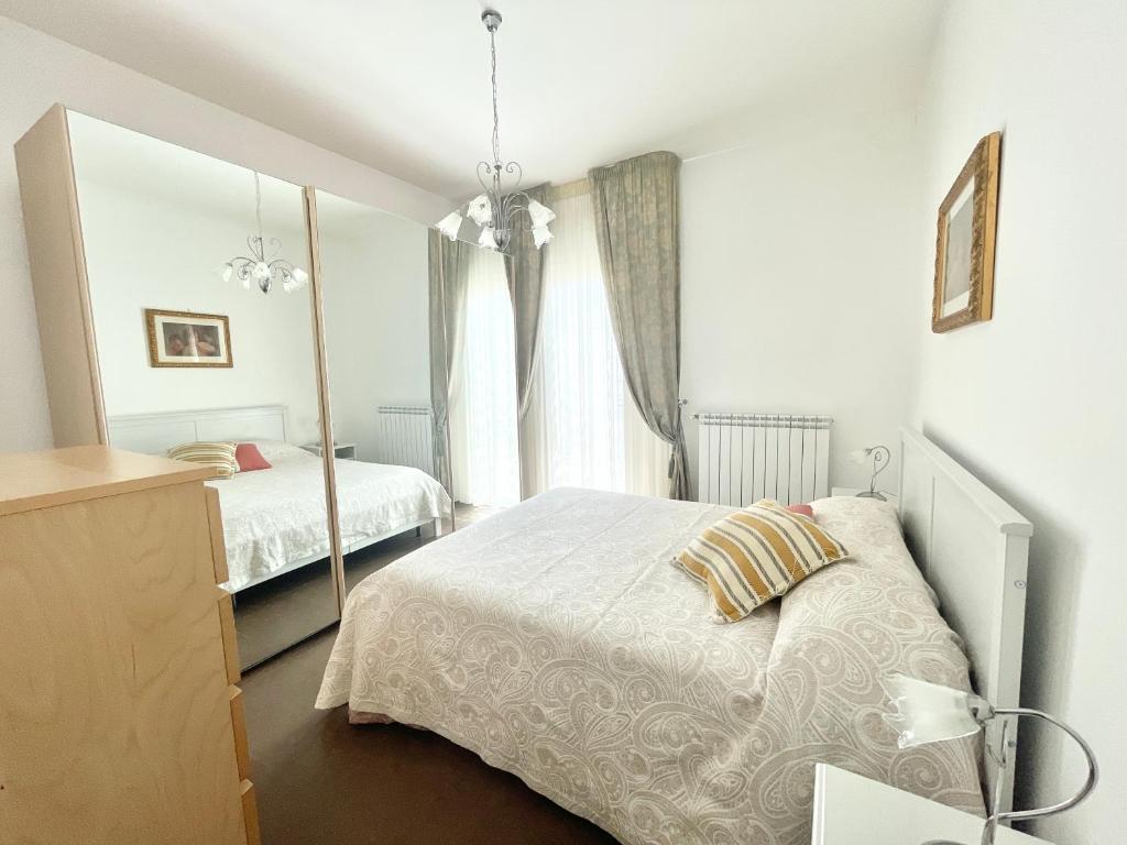 Un dormitorio blanco con una cama y un espejo. en Villa Dolce Rumore, en Bari