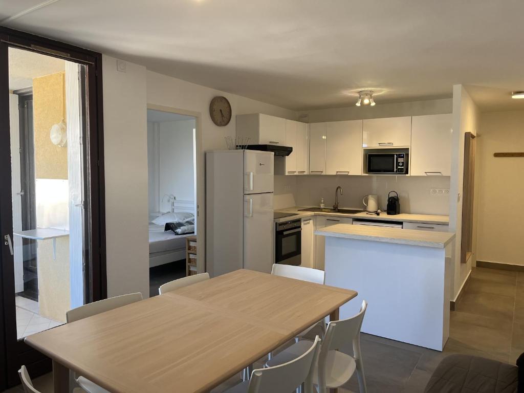 une cuisine et une salle à manger avec une table et des chaises dans l'établissement LA MIOUGRANO T3 etat neuf 5-6p, climatise, 300m de la, à Fréjus